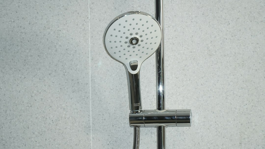 Alcachofa de ducha sobre azulejos blancos