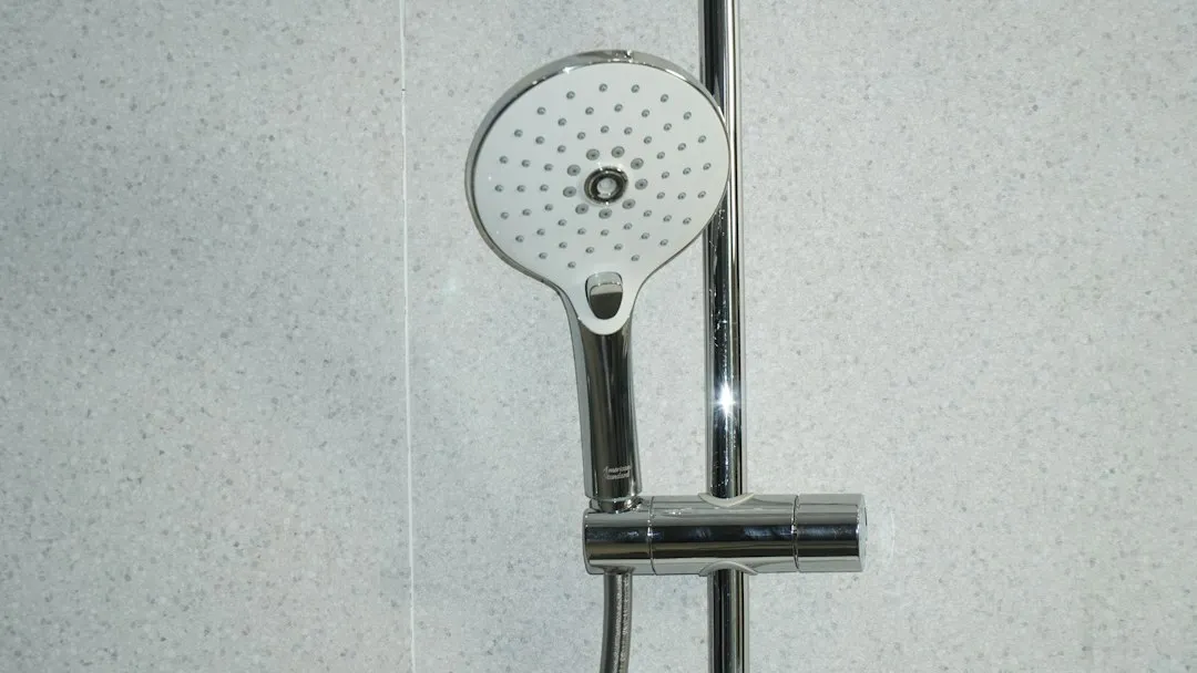 Alcachofa de ducha sobre azulejos blancos