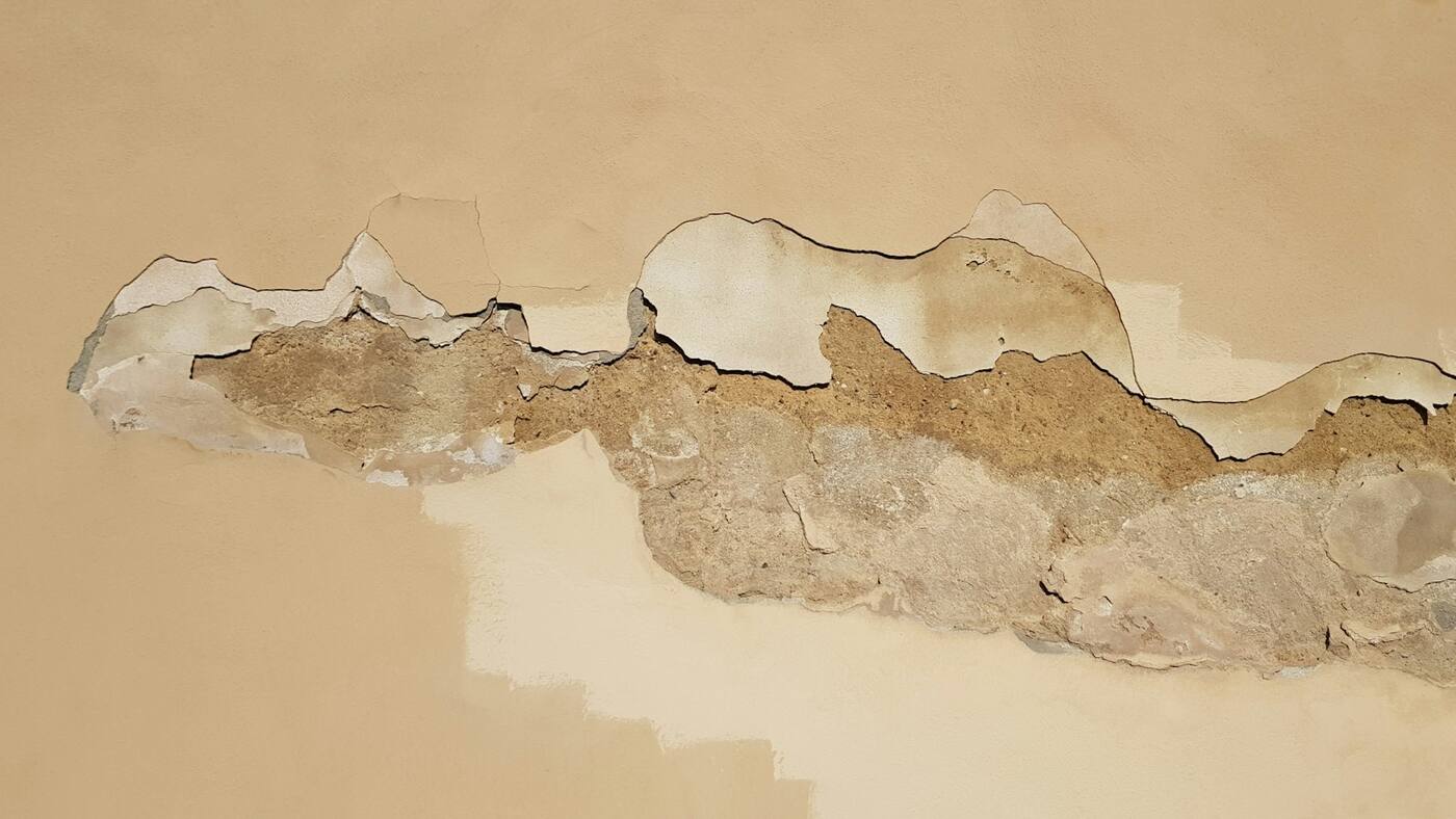 Revestimiento de pared desprendido y deteriorado