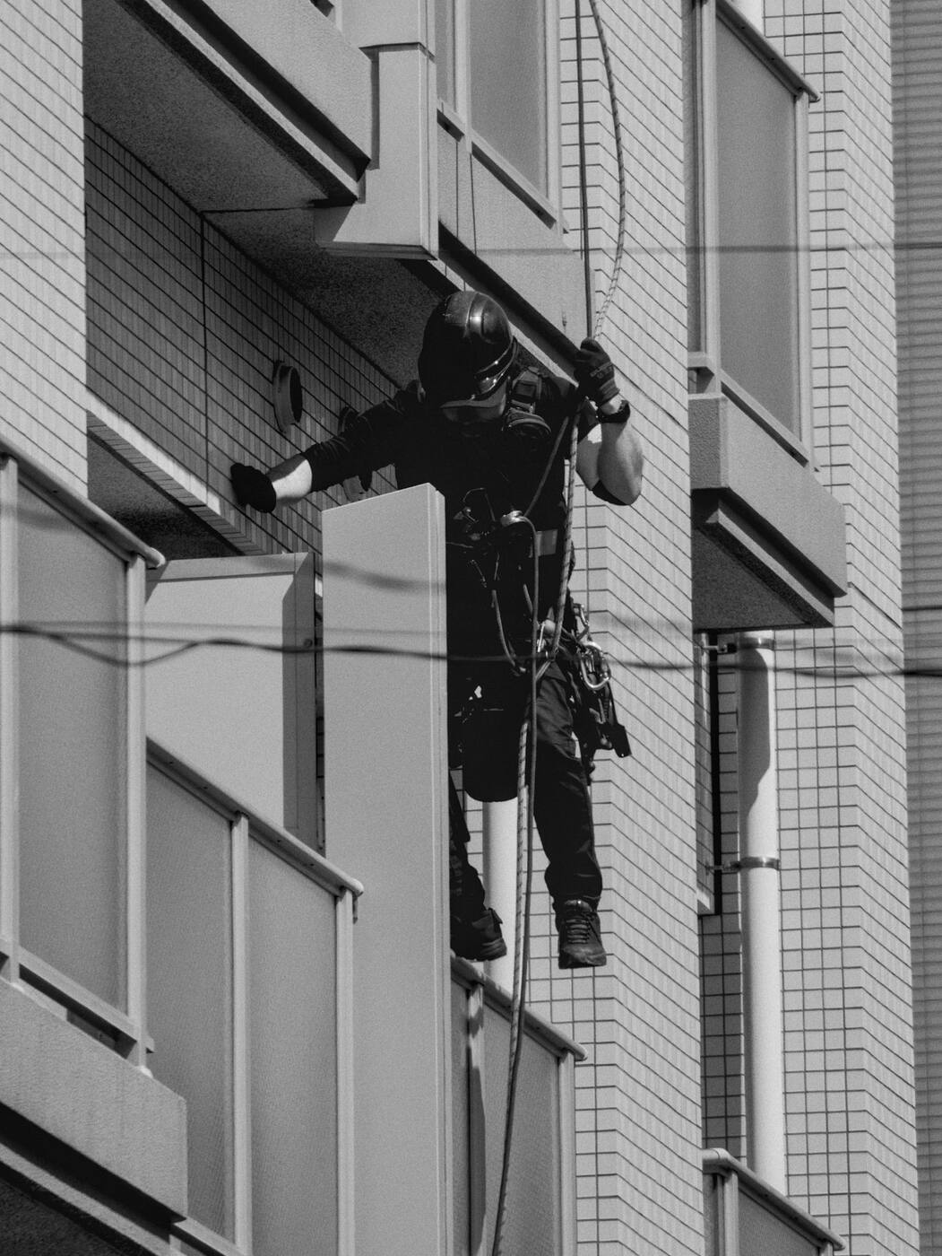 Operario suspendido trabajando en un balcón